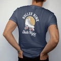 Man wearing a Navy tee, seen from the back: a classic quad roller skate with striped laces under a mirror ball, with "ROLLER RINK" and "SKATE NIGHT" in chunky 1970s swash script, printed in faded bleacher cream, mustard gold, washed red and dusty…