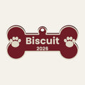 Render of a cranberry dog bone ornament with the name Biscuit, 2026 and paw prints