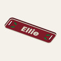 Render of a red stocking name tag reading Ellie with holly leaves and berries