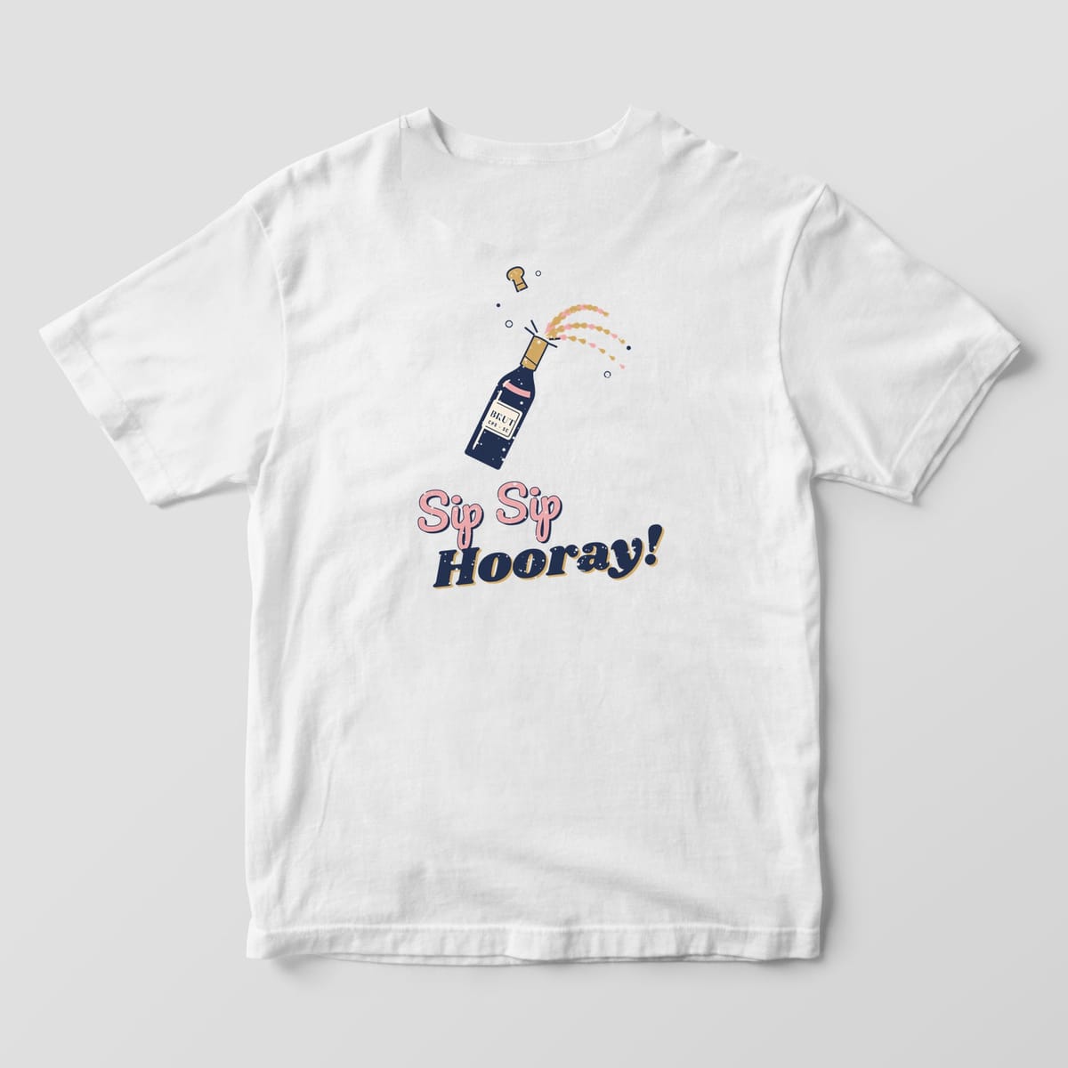 Back of a White Comfort Colors tee with a tilted champagne bottle spraying gold and pink drops above Sip Sip Hooray!
