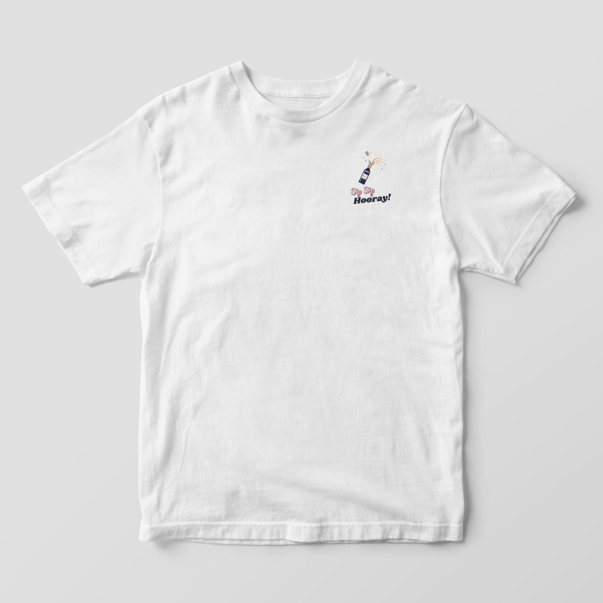 Front of a White Comfort Colors tee with a small popping champagne bottle and Sip Sip Hooray on the left chest