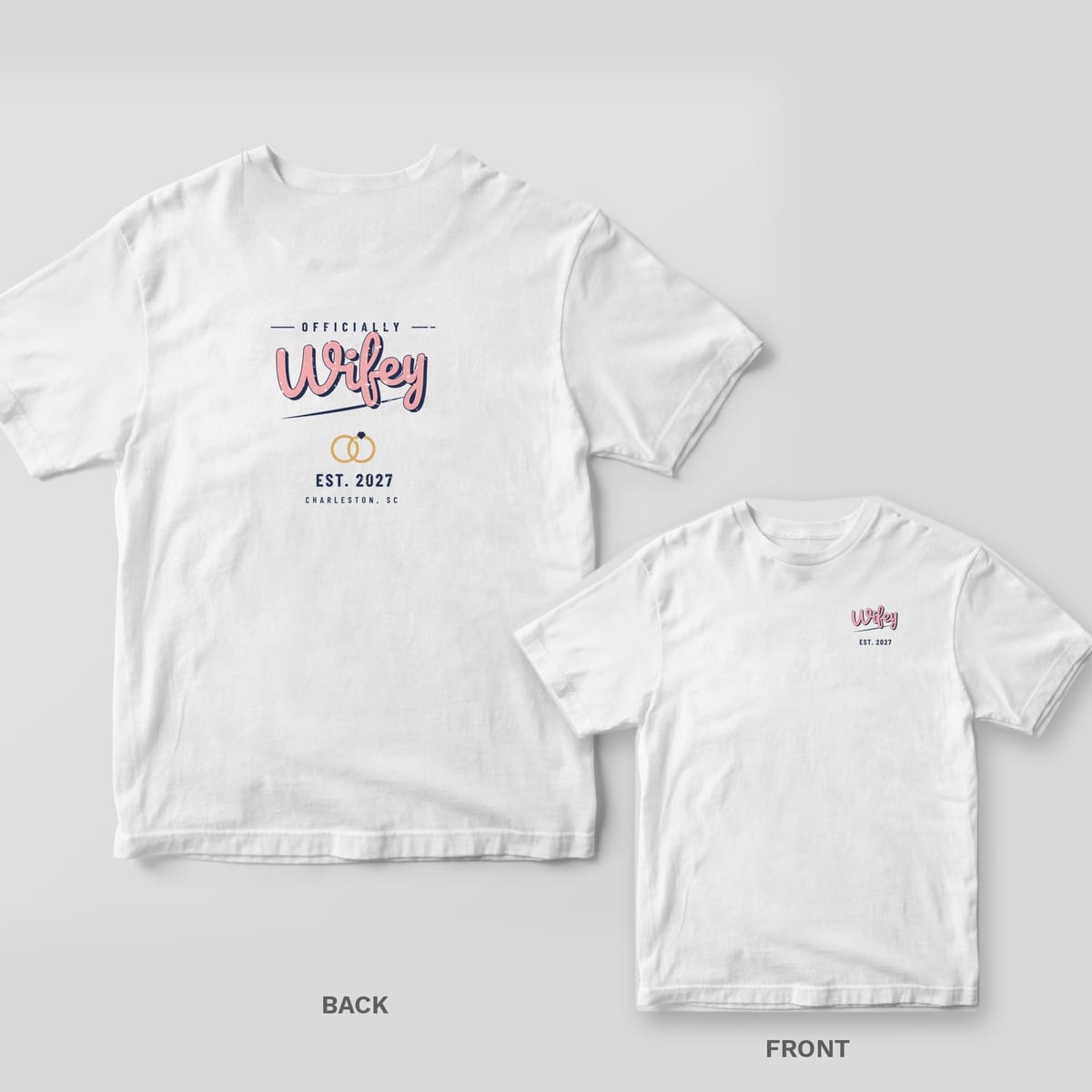 White Comfort Colors tee back and front with pink Wifey script, interlocked gold rings and EST. 2027