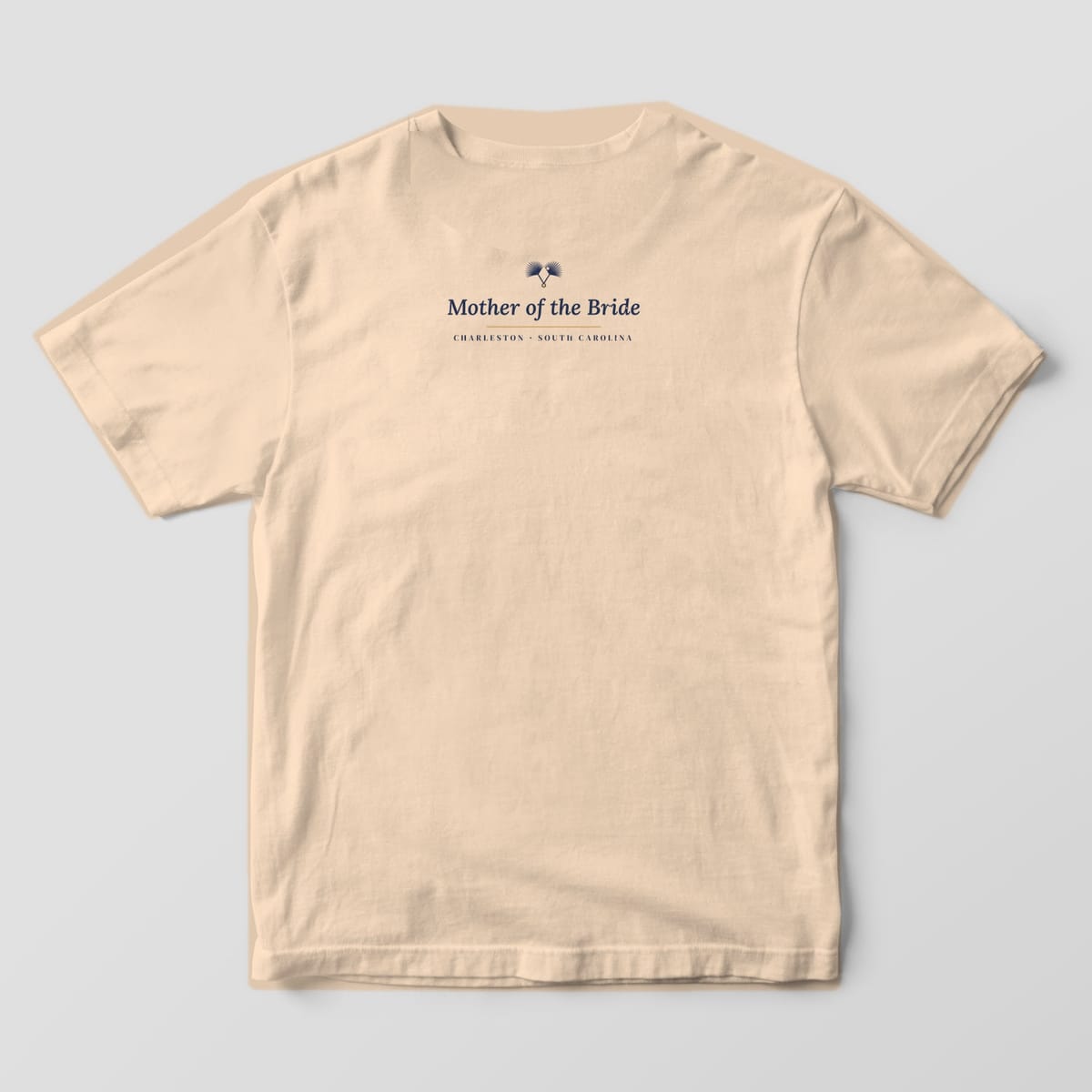 Back of an Ivory Comfort Colors tee with a small upper-back line reading Mother of the Bride, Charleston South Carolina