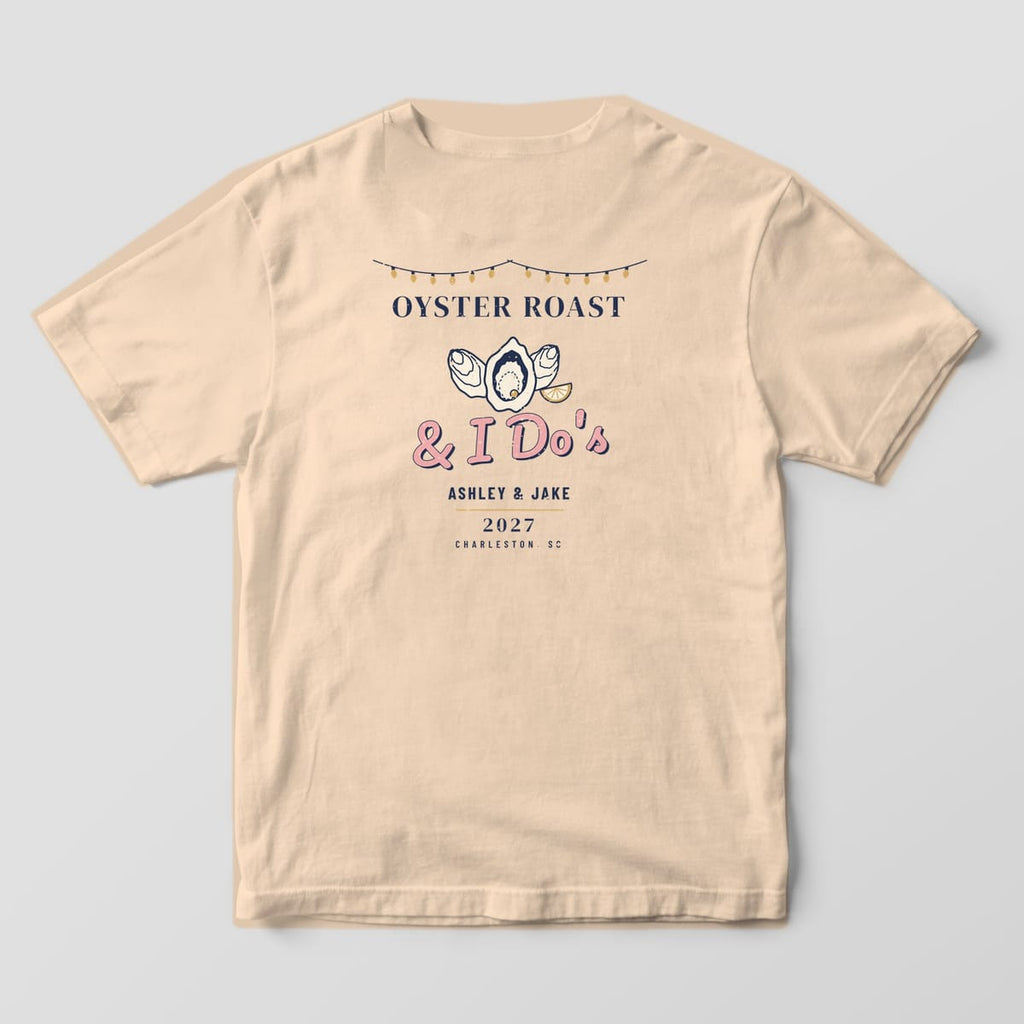 Back of an Ivory tee: string lights over OYSTER ROAST, two closed oysters, an open oyster with a pearl, lemon wedge, & I Do's, names and 2027